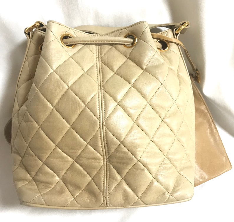 Chanel Vintage beige quilted lamb leather hobo bucket shoulder Bag with drawstrings and golden CC mark ball